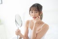 Beautiful young asian woman looking the mirror with acne problem at bedroom, trouble of beauty on face Royalty Free Stock Photo