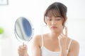 Beautiful young asian woman looking the mirror with acne problem at bedroom, trouble of beauty on face. Royalty Free Stock Photo