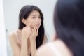 Beautiful young asian woman looking the mirror and touch face is a acne, zit treatment. Royalty Free Stock Photo