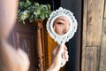 beautiful young asian woman looks at herself in the mirror, hand on cheek. Royalty Free Stock Photo