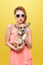 Beautiful young asian woman in nice spring dress, posing in studio with corgi puppy