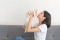 Beautiful young asian woman playing with her maltese dog on sofa in living room at home. Royalty Free Stock Photo