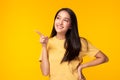 Beautiful young Asian woman pointing up to copy space and looking at copy space with smile face and happy. Pretty girl act like a Royalty Free Stock Photo