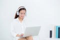 Beautiful young asian woman relax with wear headphone enjoy listening music using laptop computer Royalty Free Stock Photo