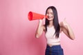 Beautiful young Asian woman show thumbs up announce with megaphone. Royalty Free Stock Photo