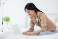 Beautiful young asian woman sitting on bed using laptop computer working from home in the bedroom. Royalty Free Stock Photo