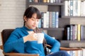 Beautiful young asian woman sitting on chair with comfort and relaxing in living room at home Royalty Free Stock Photo