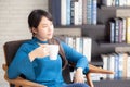 Beautiful young asian woman sitting on chair with comfort and relaxing in living room at home Royalty Free Stock Photo