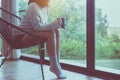 Beautiful young asian woman sitting on chair and drinking a cup of coffee in bedroom at home,Enjoys of resting time Royalty Free Stock Photo