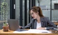 Beautiful young asian woman sitting at coffee shop using laptop. Happy young businesswoman sitting at table in cafe with tab top Royalty Free Stock Photo