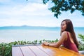 A beautiful young woman sitting and looking at the sea and blue sky Royalty Free Stock Photo