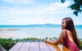 A beautiful young woman sitting and looking at the sea and blue sky Royalty Free Stock Photo