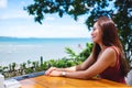 A beautiful young woman sitting and looking at the sea and blue sky Royalty Free Stock Photo