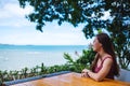 A beautiful young woman sitting and looking at the sea and blue sky Royalty Free Stock Photo