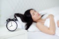 Beautiful young asian woman sleep with relax on the bed with alarm clock in the morning. Royalty Free Stock Photo