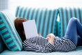 Beautiful young asian woman sleeping on sofa with book covering her face because reading book with preparing exam of college Royalty Free Stock Photo