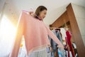 Beautiful young asian woman smiling with clothes trying on dress up fitting with modern and looking reflection mirror in the room Royalty Free Stock Photo