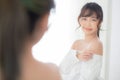 Beautiful young asian woman smiling with clothes trying on dressed up fitting with modern and looking reflect mirror Royalty Free Stock Photo