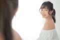 Beautiful young asian woman smiling with clothes trying on dressed up fitting with modern and looking reflect mirror in the room Royalty Free Stock Photo