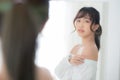 Beautiful young asian woman smiling with clothes trying on dressed up fitting with modern and looking reflect mirror in the room Royalty Free Stock Photo