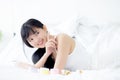 Beautiful of young asian woman smiling and lying on bed at bedroom, beauty of girl touch cheek with hygiene and healthy. Royalty Free Stock Photo