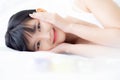 Beautiful of young asian woman smiling and lying on bed at bedroom, beauty of girl touch cheek with hygiene and healthy. Royalty Free Stock Photo