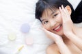 Beautiful of young asian woman smiling and lying on bed with cosmetic at bedroom, beauty of girl with hygiene and healthy. Royalty Free Stock Photo