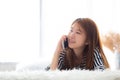 Beautiful young asian woman smiling lying relax on the bed in the morning, girl using mobile smart phone talking enjoy, Royalty Free Stock Photo