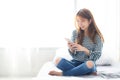 Beautiful young asian woman smiling sitting relax on the bed in the morning Royalty Free Stock Photo