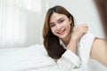 Beautiful young asian woman smiling sitting relax on the bed in the morning, girl using mobile smart phone talking enjoy Royalty Free Stock Photo