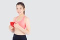Beautiful young asian woman in sport after workout drinking water from glass for thirsty isolated on white background Royalty Free Stock Photo