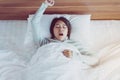 Beautiful young asian woman stretching and yawning in bedroom after wake up in the morning Royalty Free Stock Photo