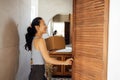 Beautiful young Asian woman takes cardboard box out of closet. Smiling cute female Korean in casual clothes with package in