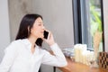 Beautiful young asian woman talking phone and smile in the coffee shop, businesswoman sitting in cafe free time, freelancer Royalty Free Stock Photo