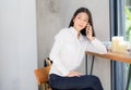 Beautiful young asian woman talking phone and smile in the coffee shop. Royalty Free Stock Photo