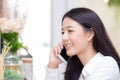 Beautiful young asian woman talking phone and smile in the coffee shop, businesswoman sitting in cafe free time Royalty Free Stock Photo