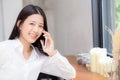 Beautiful young asian woman talking phone and smile in the coffee shop Royalty Free Stock Photo