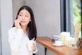 Beautiful young asian woman talking phone and smile in the coffee shop. Royalty Free Stock Photo