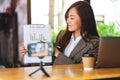 A beautiful young woman teaching business class online with laptop computer on the table Royalty Free Stock Photo