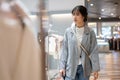 A beautiful young Asian woman in trendy clothes is walking in a shopping mall with her shopping bags Royalty Free Stock Photo