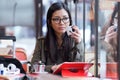 Beautiful young asian woman using her digital tablet while drinking coffee in coffee shop. Royalty Free Stock Photo