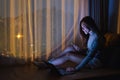 A young asian woman using mobile phone and laptop computer with bright light screen in the late night at home Royalty Free Stock Photo