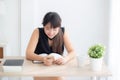 Beautiful young asian woman using touch smart mobile phone chatting message and notebook on desk. Royalty Free Stock Photo
