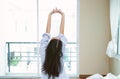 Beautiful young Asian woman is waking up in the morning in her bed and stretching his arms, back view, copy space. Woman lifestyle Royalty Free Stock Photo