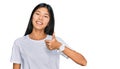 Beautiful young asian woman wearing casual white t shirt doing happy thumbs up gesture with hand Royalty Free Stock Photo