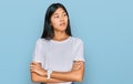 Beautiful young asian woman wearing casual white t shirt looking to the side with arms crossed convinced and confident Royalty Free Stock Photo