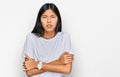 Beautiful young asian woman wearing casual white t shirt shaking and freezing for winter cold with sad and shock expression on Royalty Free Stock Photo