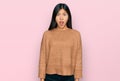 Beautiful young asian woman wearing casual winter sweater afraid and shocked with surprise expression, fear and excited face Royalty Free Stock Photo