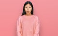 Beautiful young asian woman wearing casual winter sweater afraid and shocked with surprise expression, fear and excited face Royalty Free Stock Photo