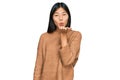 Beautiful young asian woman wearing casual winter sweater looking at the camera blowing a kiss with hand on air being lovely and Royalty Free Stock Photo